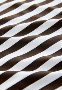 Brunt och vitt randigt tyg med en slät textur. Ränderna är breda och jämnt fördelade, vilket skapar ett vågigt mönster över tyget.