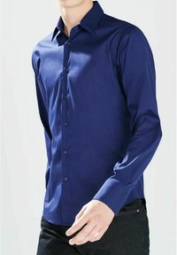 Chemise à manches longues bleu marine en tissu lisse, dotée d'un col classique, d'une fermeture à boutons et d'une coupe ajustée avec un léger éclat.