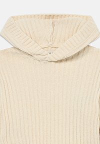 Cremfarbener Ripp-Hoodie mit hohem Kragen und strukturiertem Stoff. Besitzt vertikale Streifen und ein weiches, gemütliches Erscheinungsbild.