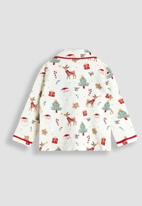 Camisa de pijama de algodón con un patrón navideño de Papá Noel, renos, árboles y regalos. Fondo crema con ribete rojo y mangas largas.