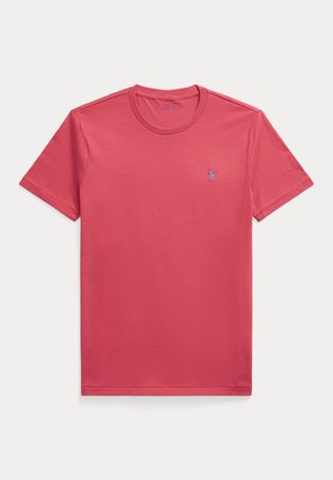 Einfaches rotes T-Shirt mit kurzen Ärmeln und Rundhalsausschnitt mit kleinem gestickten Logo auf der linken Brust vor hellem Hintergrund.