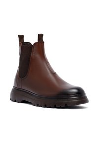 Stivale Chelsea in pelle marrone con pannelli laterali elasticizzati, punta rotonda e suola in gomma testurizzata. Punta lucida e costruzione robusta.