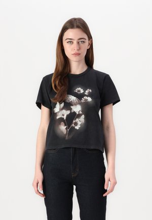Black cotton t-shirt with short sleeves, featuring a floral and butterfly graphic in light colors, round neck, and relaxed fit.