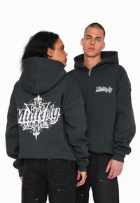 Felpa grigia con zip, dotata di una grande grafica bianca sul retro e un logo più piccolo sul davanti. Presenta un cappuccio spazioso e un design con tasca a marsupio.
