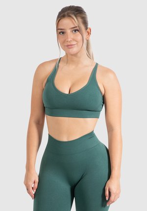 Groene sportbeha met dunne banden, ronde halslijn en zachte, rekbare stof. Een bijpassende hoge taille legging.