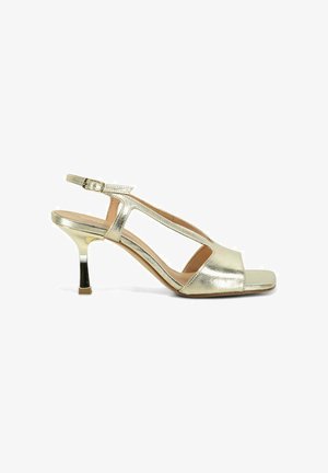 Sandale slingback pour femme en cuir doré avec bout ouvert, côtés découpés, bride à boucle réglable et talon incurvé de hauteur moyenne.