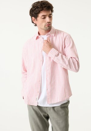 Leichtes Hemd zum Knöpfen, mit vertikalen rosa und weißen Streifen, Kragen, langen Ärmeln und lockerer Passform. Über einem weißen T-Shirt getragen.