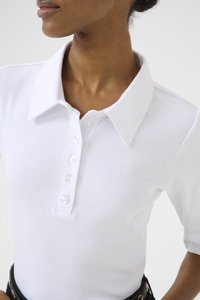 Hvit ribbet polo-skjorte med knappestolpe, korte ermer og en liten preget logo på brystet, med et klassisk kragedesign.