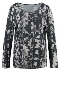 Långärmad topp med rund halsringning, prydd med ett abstrakt mönster i svart och grått samt rynkdetaljer vid midjan för en avslappnad passform.
