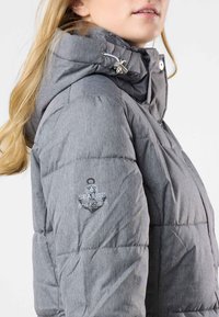 Gray, puffy jacket with a hood, featuring a textured fabric, silver hardware, and a logo patch on the left sleeve.