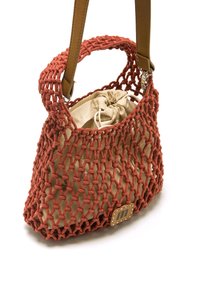 Bolsa de punto naranja con un interior de cuerda beige, que presenta un asa trenzada y una pequeña etiqueta de cuero marrón con detalle de costura.