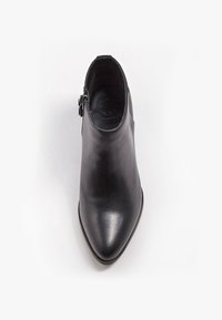 Bottine en cuir noir avec bout pointu et fermeture éclair latérale, vue de dessus sur fond blanc.