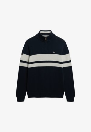 Marineblå strikketrøje med lynlås krave, der har to hvide vandrette striber og et logo på brystet. Struktureret stof, afslappet pasform.