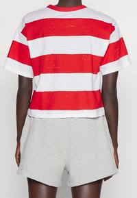 Röd- och vitrandig kortärmad t-shirt i mjuk bomull, med rund hals och korta ärmar, som matchas med grå bomullsshorts.