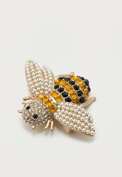 Καρφίτσα σε σχήμα μέλισσας διακοσμημένη με μικρές μαργαριτάρια, κίτρινες και μαύρες πολύτιμες πέτρες σε βάση από χρυσό μέταλλο.