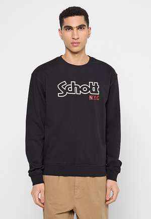 Felpa nera con colletto tondo, caratterizzata da un grande logo bianco "Schott" e "N.Y.C" in rosso. Realizzata in un tessuto morbido e testurizzato.