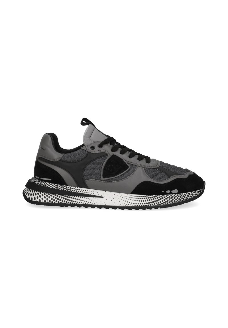 Sneaker grigia e nera con una parte superiore testurizzata, pannelli in rete e suola in gomma con accenti a pois. Comprende lacci e un passante.