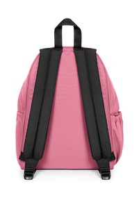 Mochila de tela rosa con correas acolchadas negras y asa superior. Presenta una superficie texturizada y bolsillos laterales para almacenamiento adicional.