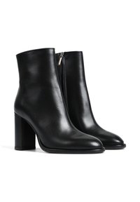 Czarne skórzane botki za kostkę o gładkiej fakturze, z wysmuklonym noskiem i średniej wysokości obcasem w kształcie bloku. Wyposażone w zamek błyskawiczny z boku.