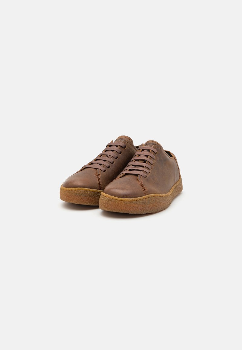 Brown leather sneakers with a rounded toe, featuring a textured rubber sole and matching laces. No visible branding on the upper.