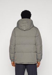 Gray puffer jacket with a hood, featuring a quilted design, elastic cuffs, and a straight hem. No visible logos or patterns.