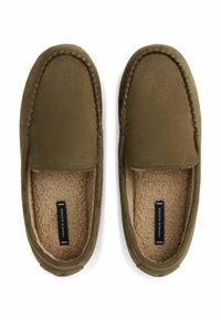 Zapatillas deslizables de color verde oliva con exterior de ante, suave forro de piel sintética y costuras a lo largo de los bordes. Logotipo visible en la plantilla.
