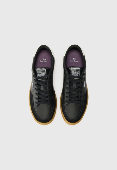Schwarze Ledersneaker mit niedrigem Profil, runder Zehenpartie, kontrastierendem weißen Absatz und Sohle aus Gummi. Ausgestattet mit schwarzen Schnürsenkeln und einer lila Innensohle.