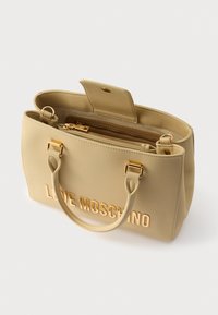 Μπεζ τσάντα ώμου με χρυσά γράμματα «LOVE MOSCHINO». Διαθέτει υλικό που μοιάζει με δέρμα, διπλές λαβές και εσωτερικό διαμέρισμα με φερμουάρ.