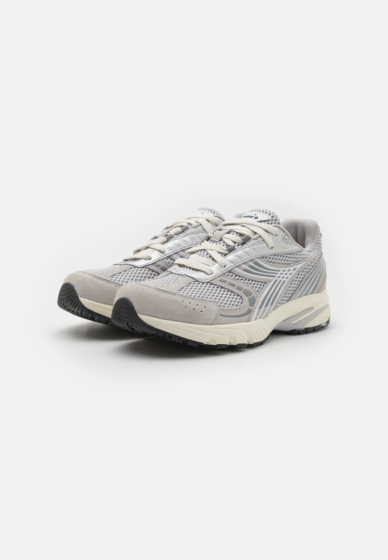 Lichtgrijze sportschoenen met bovenwerk van mesh en suède, voorzien van een versterkte neus, reflecterende accenten, platte veters en een gestructureerde zwarte rubberen zool.