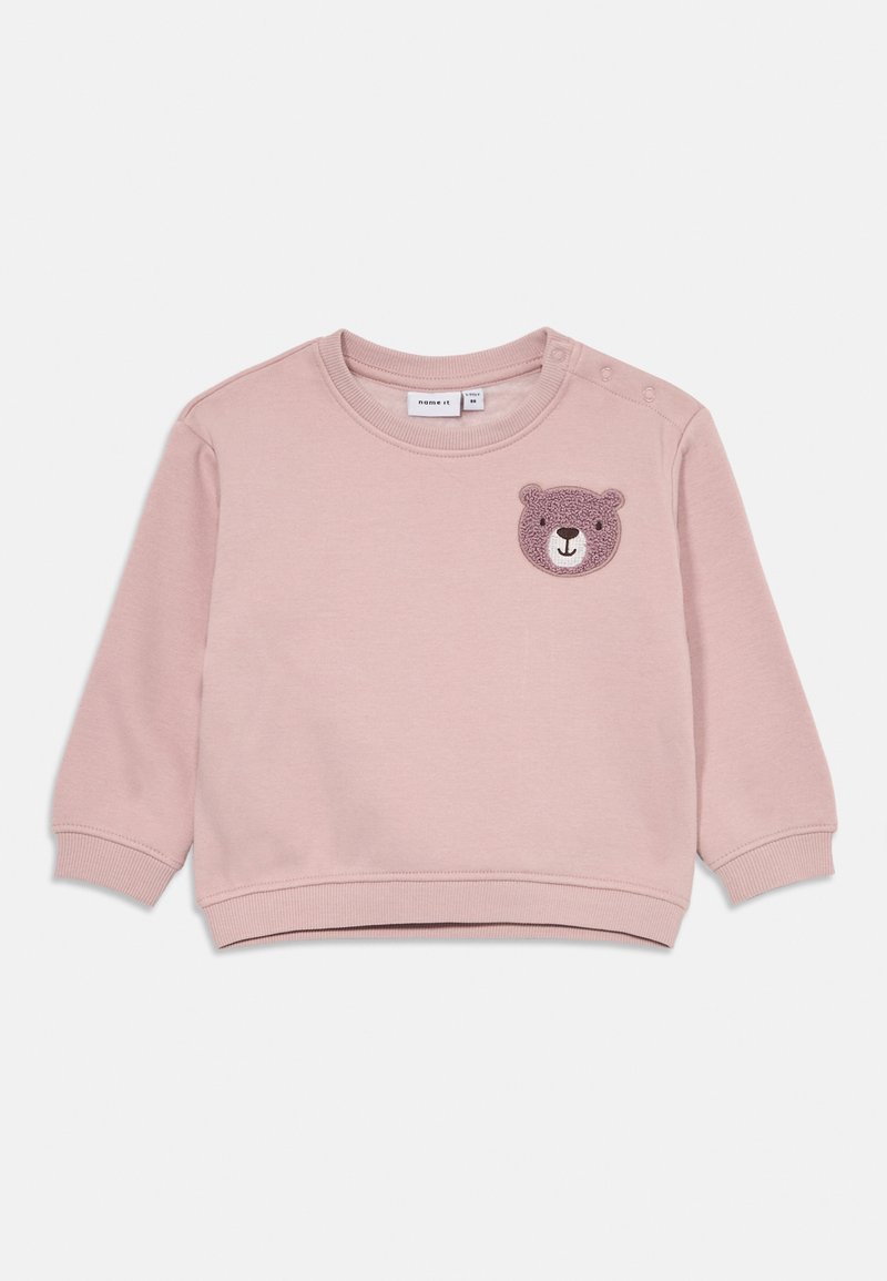 Felpa per bambini di colore rosa chiaro con maniche lunghe e un'appliqué a forma di orso testurizzato sul petto sinistro, con chiusure a pressione sulle spalle.