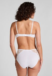 Weißer Spitzen-BH mit Rückenteil aus Spitze und hochgeschnittenen Unterhosen, gefertigt aus weichem Stoff, mit verstellbaren Trägern und einem nahtlosen Design, das mit floralen Spitze-Akzenten verziert ist.