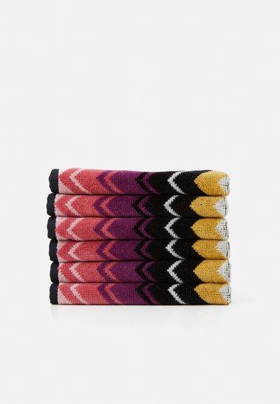 Colorful socks stacked vertically, featuring a chevron pattern in shades of pink, purple, black, and yellow with textured knit material.