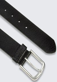 Zwarte rubberen riem met een textuur, zilveren metalen gesp en vijf verstelgaten, met een gebogen punt voor een afgewerkte uitstraling.