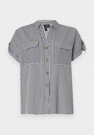 Blusa a righe a maniche corte in blu navy e bianco, con due tasche frontali, chiusura frontale con bottoni e vestibilità comoda. Presenta bottoni in tono dorato.