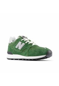 Vihreät mokka- ja verkkojuoksukengät, joissa on valkoiset nauhat, valkoinen pohja, musta pinta ja valkoinen "N"-logo sivussa.