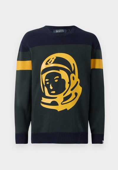 Pleteni pulover v temno zeleni in mornarsko modri barvi. Na sprednji strani ima drzen grafični motiv astronavta v rumeni barvi, rokavi pa so okrašeni z navpičnimi črtami.