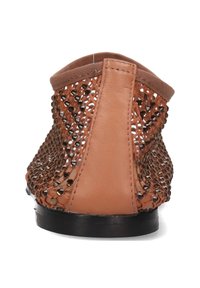 Brun öppen vävd backsko med en mjuk läderpanel, prydd med metallnitar och en texturerad finish. Elastisk rem vid öppningen.