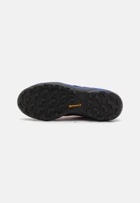 Sportliche Schuhsohle mit einer schwarzen Gummisohle, die multidirektionale Stollen und ein sichtbares orangefarbenes Continental-Logo aufweist.