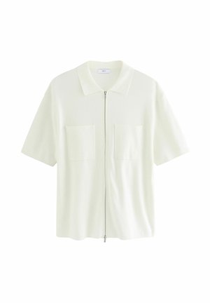 Chemise à manches courtes, blanche, à fermeture éclair, en tissu texturé, dotée d'un col et de deux poches avant avec rabats carrés.