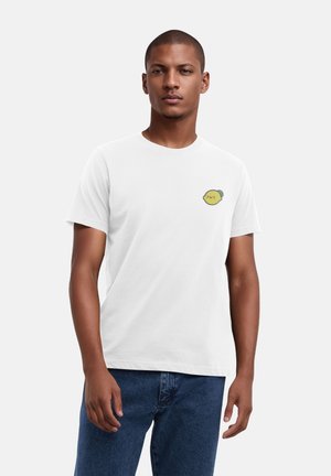 White cotton t-shirt with short sleeves, featuring a small yellow cartoon lemon patch on the left chest. Casual fit, round neckline.