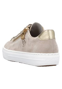 Baskets en daim beige avec des accents dorés et une semelle en caoutchouc blanc. Dotées d'une fermeture éclair décorative et d'un panneau texturé sur le côté.