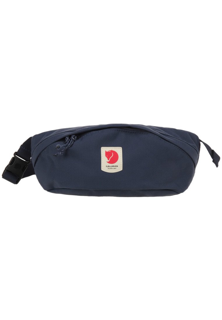 Marsupio in tessuto blu navy con forma curva, tasca frontale con zip e un'etichetta rossa con un simbolo di una volpe stilizzata. Cinghia regolabile.
