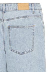 Hellblaue Jeans aus Denim, Rückansicht, mit einer einzigen Tasche und einem tanfarbenen Leder-Brandpatch mit der Aufschrift "PULZ JEANS".