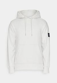 Vit luvtröja med dragsnodd, framficka, ribbade ärmar och en märkesapplikation på vänster ärm. Slät textur.