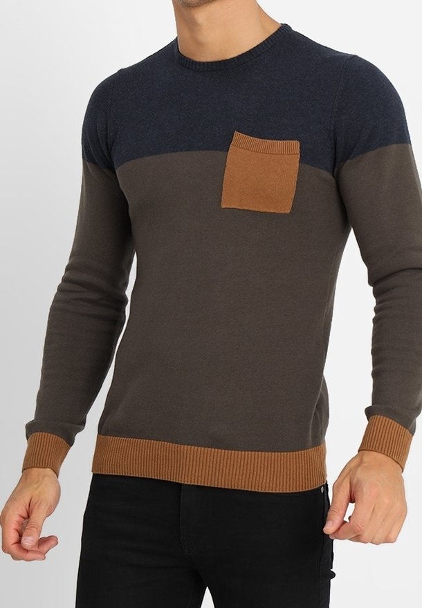 Stickad tröja med en mörkblå överdel, brun torso och ribbad bruna detaljer på kragen och fållen; har en liten bröstficka.