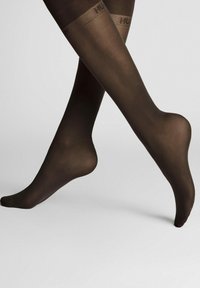 Durchsichtige, dunkelbraune Strumpfhosen mit glatter Textur und enger Passform. Mit einem gemusterten oberen Bund und Branding.