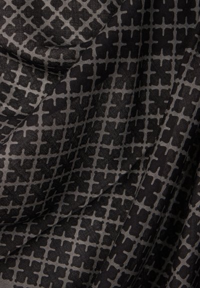 Tissu sombre avec un motif géométrique répétitif de croix noires et de lignes en grille, montrant des plis doux et une texture.