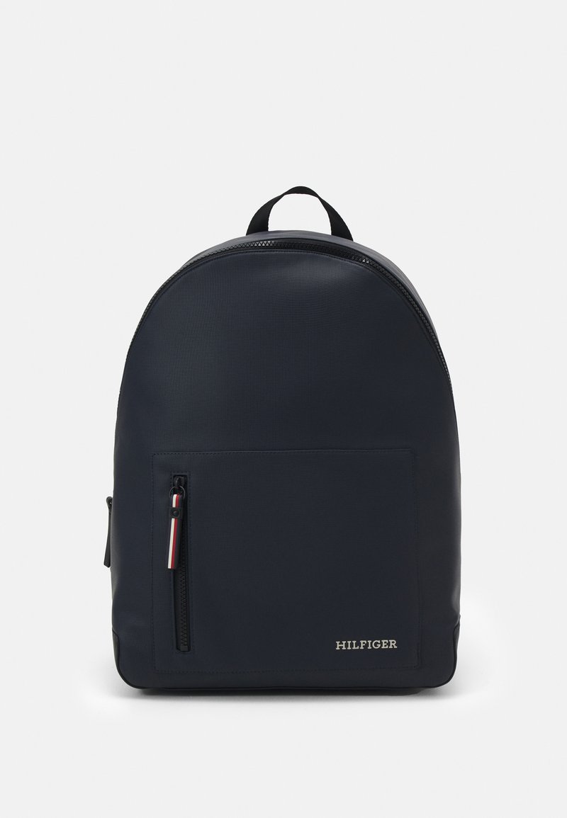 Zaino blu navy dalla forma arrotondata, realizzato in materiale testurizzato. Presenta una tasca frontale con zip e un piccolo logo nell'angolo in basso a destra.