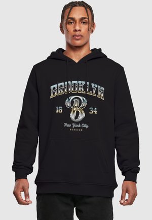 Svart hoodie med en framficka, dragsko i huven och metalliska textgrafiker: "BROOKLYN 16 34 New York City" med ett stiliserat 'B'.