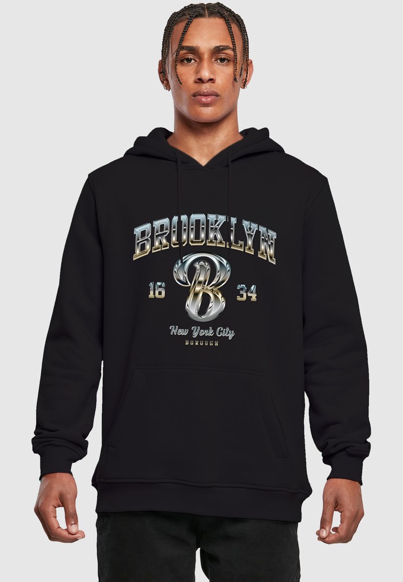 Sort hættetrøje med en frontlomme, snoretræk i hætten og metallisk tekstgrafik: "BROOKLYN 16 34 New York City" med et stiliseret 'B'.